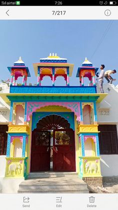 a man standing on top of a colorful building next to another person climbing up the stairs