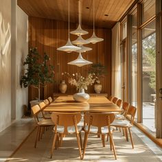 a dining room table surrounded by chairs and vases