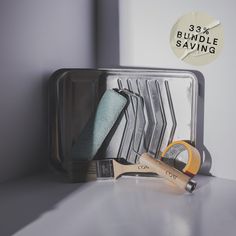 a metal container filled with different types of paint brushes and other items on top of a table