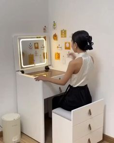 a woman sitting at a desk with a mirror on it