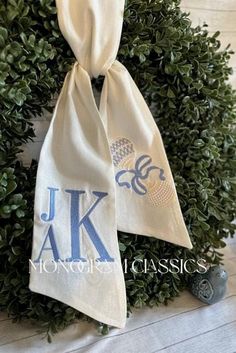 a wreath with two monogrammed towels hanging from it