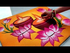 someone is painting flowers on an orange surface