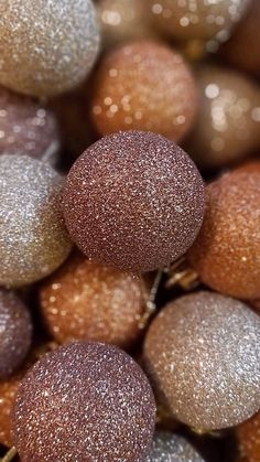 closeup of christmas balls with glitter on them in brown and silver colors, as well as gold speckles