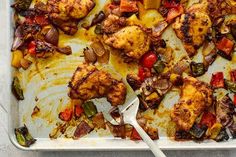 a pan filled with chicken and vegetables on top of a table