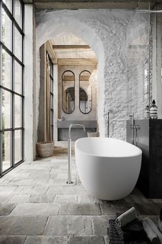 a large white bath tub sitting next to a window