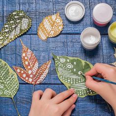 someone is painting leaves with acrylic paint