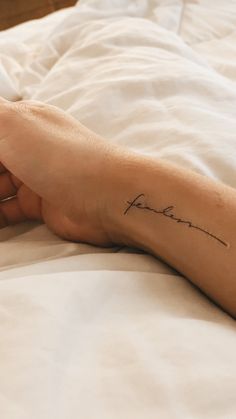 a woman's foot with a tattoo on it that reads, love is forever