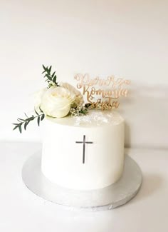 a white cake with a cross and flowers on top