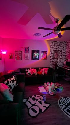 a living room filled with lots of furniture and pink lighting on the ceiling above it