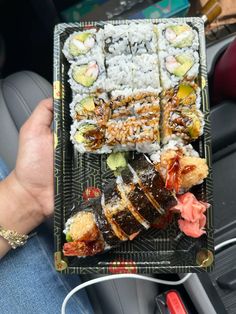 sushi platter being held in the back seat of a car