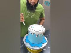 a man cutting into a blue and white cake on top of a table with a knife