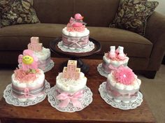 a table topped with cakes covered in pink and white frosting