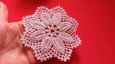 someone is holding a pink brooch in their left hand and it looks like they are made out of crochet