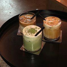 three different types of drinks sitting on top of a black table next to each other