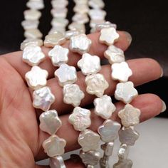 a hand is holding some white pearls