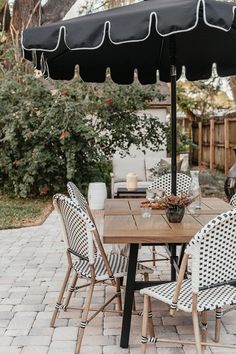 an outdoor table with chairs and an umbrella