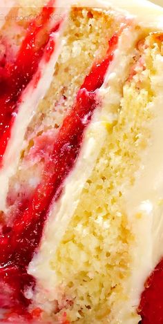 a piece of cake with white frosting and strawberries on top