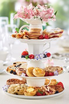 three tiered trays filled with different types of pastries and desserts on top of each other