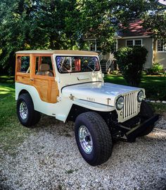 an old jeep is parked in the gravel