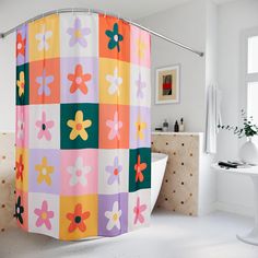 a colorful shower curtain with flowers on it in a white and pink bathroom area next to a sink