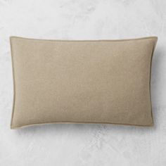 a beige pillow sitting on top of a white wall