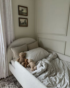 there is a bed with two teddy bears on it