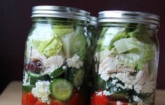 two mason jars filled with different types of salads and veggies in them