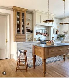 a large kitchen with an island in the middle and two stools next to it