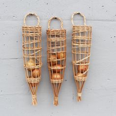 three baskets with apples in them hanging on the wall