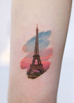 the eiffel tower tattoo on the left thigh is painted with watercolors