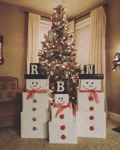 christmas presents are stacked up in front of a decorated christmas tree with snowmen on them