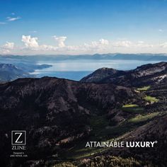 an aerial view of the mountains and water in the distance with blue skies above them