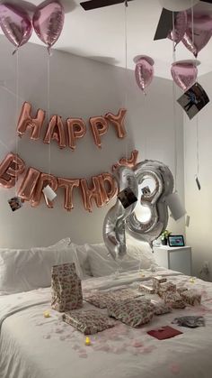 a bedroom decorated with balloons and gifts for a happy birthday to someone who is in love