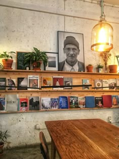 a wooden table sitting in front of a shelf filled with pictures and books on it