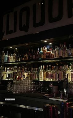 the bar is stocked with many different types of liquor bottles and glasses on it's shelves