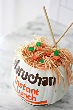 a white pumpkin decorated with noodles and carrots