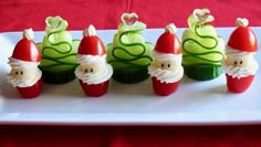 there are many small cupcakes decorated like santa claus and elf hats on a white plate