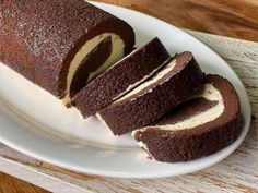 a chocolate cake with cream filling on a white plate