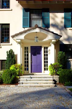 a purple door in front of a white house