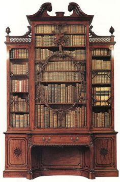 an old wooden bookcase with many books on it