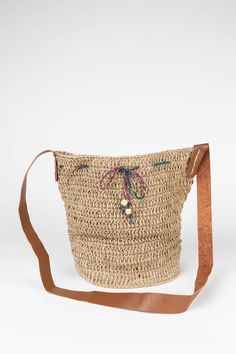 Make every day feel like a day at the beach with the crocheted Jute Bucket Bag with leather handles and accented with sea blue wooden beads on a cotton drawstring. Ethically handcrafted in small batches by environmentalist artisans with Prokritee, an organization in Bangladesh that provides jobs and skills training for women in under-resourced communities. Prokritee improves women's standard of living with safe jobs, fair wages, and the goal of self-reliance, helping mothers send their children Everyday Bohemian Jute Bucket Bag, Bohemian Natural Bucket Bag For Daily Use, Everyday Bohemian Jute Shoulder Bag, Bohemian Everyday Jute Shoulder Bag, Bohemian Natural Beach Bag For Everyday Use, Natural Coastal Beach Bag For Everyday Use, Bohemian Style Natural Beach Bag, Bohemian Jute Bucket Bag For Travel, Bohemian Travel Jute Bucket Bag