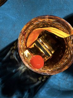 an empty glass filled with liquid on top of a blue cloth