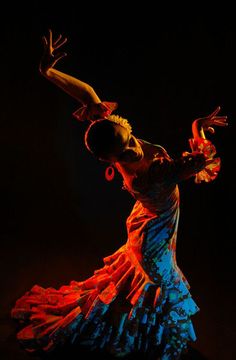 a woman in a colorful dress is dancing