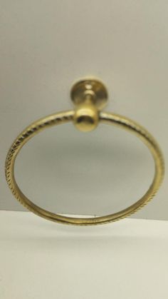 a gold ring with a ball on the top and a rope around it's edge