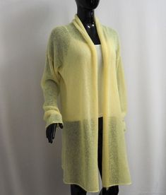 a mannequin wearing a yellow cardigan sweater and black leggings,