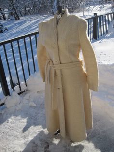 Vintage white 1980's long winter coat. Poodle, Boucle Textured, nubby weave. Size 13 / 14 US woman's clothing size.  4 large button front, 2 side pockets, sash belt with loops at seams, silk lining.  Set in sleeves. Shawl collar. Cream, ivory; winter wedding 44 inches long, neck to bottom of hem. Vintage - used; very good vintage condition. No rips; no snags. Please see pictures for details. Union made; made in USA. Dry clean only. Long Fall Wedding Outerwear, Cream Winter Wedding Outerwear, Winter Wedding Long Coat, Winter Wedding Outerwear With Buttons, Long Winter Wedding Outerwear, Vintage Winter Wedding Outerwear, Vintage Wedding Outerwear With Buttons, Winter Wedding Outerwear, Winter Wedding Coat