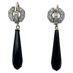 Diamond and Black Onyx Platinum and 14 Karat White Gold Dangle Earrings These beautiful dangle drop earrings combine 1.2 Carats of stunning white diamonds with faceted black onyx drops in a dramatic design in Platinum atop 14 Karat White Gold. The earrings feature a faceted 27mm teardrop-shaped Black Onyx. The tops of the earrings are set with 24 2.2mm European Cut Diamonds which total approximately 1.20 Carats. The diamonds are brilliantly white and H color. Diamonds 24 European Cut Diamonds Co Luxury Black Diamond Earrings For Formal Occasions, Luxury Black Diamond Earrings For Evening, Black Diamond Earrings With Accents For Formal Events, Black Diamond Earrings With Accents For Formal Occasions, Formal Black Diamond Earrings, Classic Black Diamond Earrings For Formal Occasions, Black Diamond Earrings For Formal Occasions, Formal Black Diamond Earrings Fine Jewelry, Elegant Black Diamond Earrings For Formal Occasions