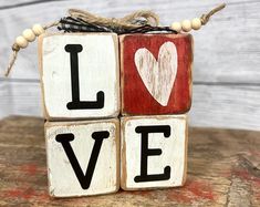 a wooden block with the word love spelled in black and white on top of it