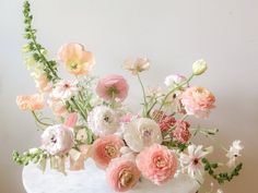 a white cake topped with lots of pink and white flowers