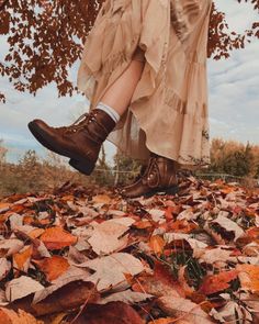 a woman's legs and shoes are shown in the leaves